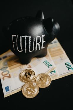 Una alcancía negra con la palabra futuro escrita está encima de un montón de dinero.